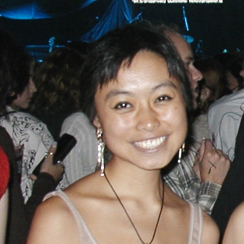 Sabine, an East Asian woman with short hair, smiling at a concert